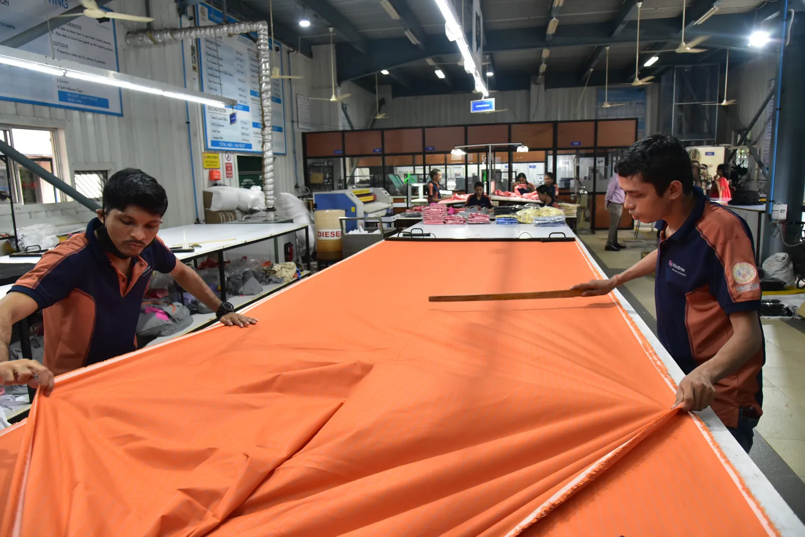 Trainees spreading fabric on the cutting table in the apparel centre